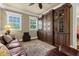 Cozy living room with a large dark wood bookcase and large windows allowing natural light to enter the space at 27852 Lake Jem Rd, Mount Dora, FL 32757