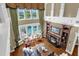 High-angle shot of a beautifully decorated living room with a fireplace, built-in shelving, and large windows overlooking the pool at 27852 Lake Jem Rd, Mount Dora, FL 32757