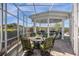 Stylish outdoor kitchen featuring an outdoor bar, seating, and a lovely, screened outdoor space at 27852 Lake Jem Rd, Mount Dora, FL 32757