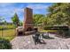 Charming brick outdoor fireplace with a built-in grill, surrounded by comfortable seating and lush greenery at 27852 Lake Jem Rd, Mount Dora, FL 32757