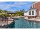 Backyard pool with a water feature, lounge chairs and umbrella near the house at 27852 Lake Jem Rd, Mount Dora, FL 32757