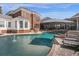 Beautiful backyard pool featuring a tanning ledge, covered patio and lush landscaping at 27852 Lake Jem Rd, Mount Dora, FL 32757