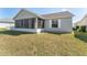 Exterior view of a home featuring a screened porch and a well-maintained backyard at 3009 Batally Ct, The Villages, FL 32162