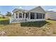 Exterior view of a home featuring a screened porch and white picket fence in the backyard at 3009 Batally Ct, The Villages, FL 32162