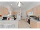 Open kitchen featuring light wood cabinets, white appliances, and a breakfast bar, and a ceiling fan at 3009 Batally Ct, The Villages, FL 32162