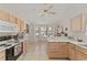 Well-lit kitchen with a breakfast bar, light wood cabinets, and a view to the bay window seating area at 3009 Batally Ct, The Villages, FL 32162