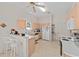 Bright kitchen featuring an eat-in breakfast bar, white appliances, and light wood cabinetry at 3009 Batally Ct, The Villages, FL 32162