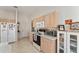 Bright kitchen showcasing light wood cabinets, white appliances, and a breakfast bar, with natural light at 3009 Batally Ct, The Villages, FL 32162