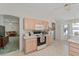 Bright kitchen featuring light wood cabinets, white appliances and a breakfast bar, and view to dining room at 3009 Batally Ct, The Villages, FL 32162