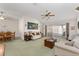 Spacious living room featuring plush sofas, a ceiling fan, and sliding glass doors to the screened porch at 3009 Batally Ct, The Villages, FL 32162