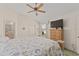 Bright main bedroom features a ceiling fan and a dresser with a TV at 3009 Batally Ct, The Villages, FL 32162