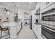 Modern kitchen featuring white cabinetry, stainless steel appliances, large island, and decorative backsplash at 3009 High Pointe St, Clermont, FL 34711