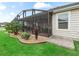 View of the screened-in patio and lawn with attractive landscaping enhances the property's appeal at 3047 Bevill Ln, The Villages, FL 32163