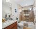 Bathroom featuring a bathtub with shower and wood cabinet with granite countertop at 3047 Bevill Ln, The Villages, FL 32163