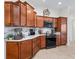 Well-equipped kitchen with wood cabinets, granite countertops, and stainless steel appliances at 3047 Bevill Ln, The Villages, FL 32163