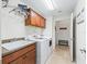 Well-lit laundry room features a utility sink, modern appliances, and upper cabinets for storage at 3047 Bevill Ln, The Villages, FL 32163