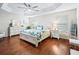 Main bedroom with a ceiling fan, wood floors, and tray ceiling at 3047 Bevill Ln, The Villages, FL 32163