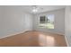 Bright bedroom with wood floors and a large window offering natural light and views of the outside at 3056 Saint Thomas Ln, The Villages, FL 32162