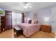 Comfortable bedroom featuring a plush bed with lavender bedding, wood floors, and ample natural light at 3056 Saint Thomas Ln, The Villages, FL 32162