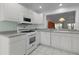 The kitchen has white cabinets and appliances, and a pass-through window that adds natural light at 3056 Saint Thomas Ln, The Villages, FL 32162