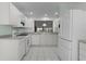 This kitchen offers all white appliances, cabinets, and tile floors, complete with a pass-through window at 3056 Saint Thomas Ln, The Villages, FL 32162