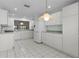 This eat-in kitchen has white cabinets and appliances and is adjacent to dining and living area at 3056 Saint Thomas Ln, The Villages, FL 32162