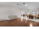Spacious living room featuring wood floors, a ceiling fan, and an adjacent dining area with tile floors at 3056 Saint Thomas Ln, The Villages, FL 32162