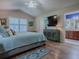 Bedroom featuring hardwood floors, a plush queen-sized bed, and an ensuite bathroom at 3142 Islawild Way, The Villages, FL 32163