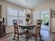 Cozy dining area with a round table, four chairs, and plantation shutters, and a sliding glass door at 3142 Islawild Way, The Villages, FL 32163