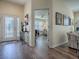 Foyer featuring wood flooring, a decorative front door, artwork, and an open view to the living area at 3142 Islawild Way, The Villages, FL 32163