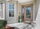 Beautiful front entrance featuring a decorative glass door, sidelight, and manicured landscaping at 3142 Islawild Way, The Villages, FL 32163