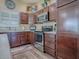 Kitchen with stainless steel appliances, dark cabinetry, wood floors and light countertops at 3142 Islawild Way, The Villages, FL 32163