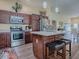 Kitchen with stainless steel appliances, granite countertops, and a breakfast bar, flowing into living area at 3142 Islawild Way, The Villages, FL 32163