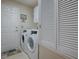 Bright laundry room featuring a modern washer and dryer, with ample storage and convenient access to the outside at 3142 Islawild Way, The Villages, FL 32163