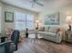 Comfortable living room featuring hardwood floors, neutral paint, and a cozy sitting area at 3142 Islawild Way, The Villages, FL 32163