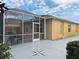 Exterior view of a screened-in lanai with patio and a yellow house at 3285 Archer Ave, The Villages, FL 32162