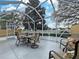 Relaxing screened patio includes a dining table, chairs, and views of the manicured backyard and lush greenery at 3285 Archer Ave, The Villages, FL 32162