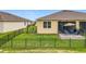 Backyard with a black metal fence, green grass, and a patio with outdoor chairs and a grill at 3449 Meadow Beauty Way, Clermont, FL 34714