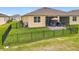 Spacious backyard with a black metal fence, green grass, and a patio with outdoor seating and a grill at 3449 Meadow Beauty Way, Clermont, FL 34714