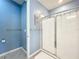 Bathroom shower with a sliding glass door, tile flooring, and blue paint at 3449 Meadow Beauty Way, Clermont, FL 34714