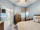 Comfortable bedroom with light blue walls, and a plush bed with a patterned throw blanket at 3449 Meadow Beauty Way, Clermont, FL 34714