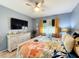 Bright bedroom featuring light wood laminate flooring and yellow and white curtains at 3449 Meadow Beauty Way, Clermont, FL 34714