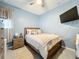 Comfortable bedroom with a wooden bed frame, ceiling fan, and a mounted TV for relaxing evenings at 3449 Meadow Beauty Way, Clermont, FL 34714