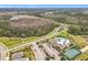 Aerial view of neighborhood clubhouse with pool, tennis courts and parking at 3449 Meadow Beauty Way, Clermont, FL 34714