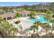 Aerial view of the clubhouse, pool, and lounge area with palm trees and shade coverings for relaxing by the water at 3449 Meadow Beauty Way, Clermont, FL 34714