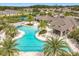 Aerial view of the community pool, clubhouse and sun loungers with palm trees and a covered eating area at 3449 Meadow Beauty Way, Clermont, FL 34714