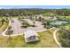 Aerial view of the community clubhouse, pool, tennis courts, and a picnic pavilion with ample parking at 3449 Meadow Beauty Way, Clermont, FL 34714