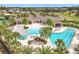 Aerial view of the community pool, clubhouse, and lounge areas, surrounded by lush greenery and palm trees at 3449 Meadow Beauty Way, Clermont, FL 34714