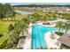 Aerial view of the beautiful community pool with palm trees, lounge chairs, and a lap pool at 3449 Meadow Beauty Way, Clermont, FL 34714