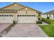 Inviting home with a brick driveway, a two-car garage, and well-manicured landscaping at 3449 Meadow Beauty Way, Clermont, FL 34714